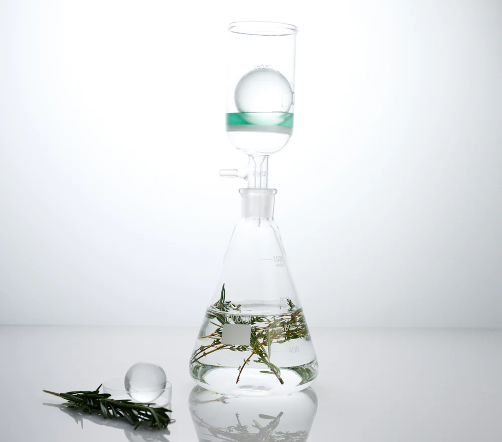A glass beaker holds botanical ingredients. Before + After Vitals are cosmetic surgery supplements that include propriety amino acids vital for tissue repair.