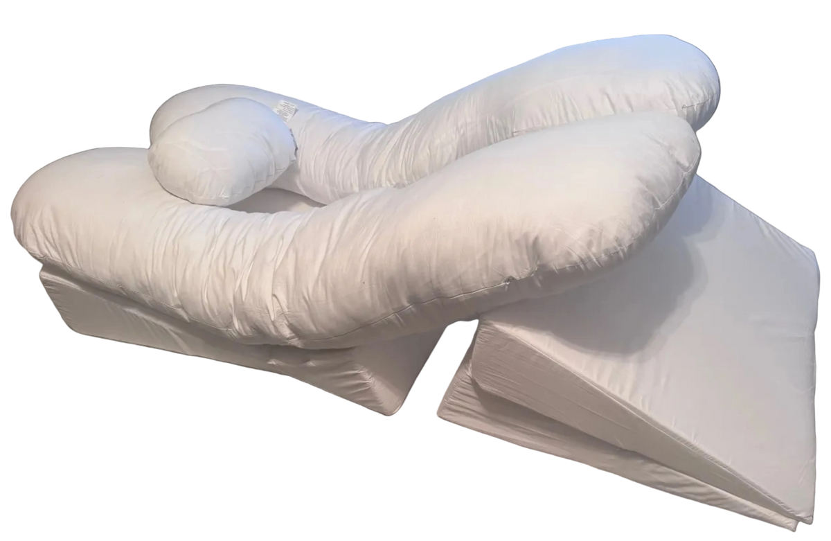 The BBL Add On Set features a large white U-shaped body pillow, a small cylindrical pillow, and two triangular foam wedges, all designed as a supportive pillow system perfect for comfortable rest during pregnancy, medical use, or recovery following a Brazilian Butt Lift (BBL) procedure, displayed against a plain background.