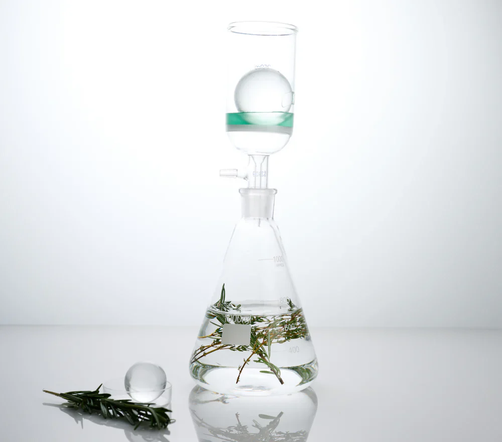 A detail photo of a glass beaker with botanical ingredients. Before + After Vitals are the world's leading supplements for healing, created by a plastic surgery clinical dietitian and including meticulously selected ingredients in clinically effective dosages, patented to ensure one-of-a-kind quality.
