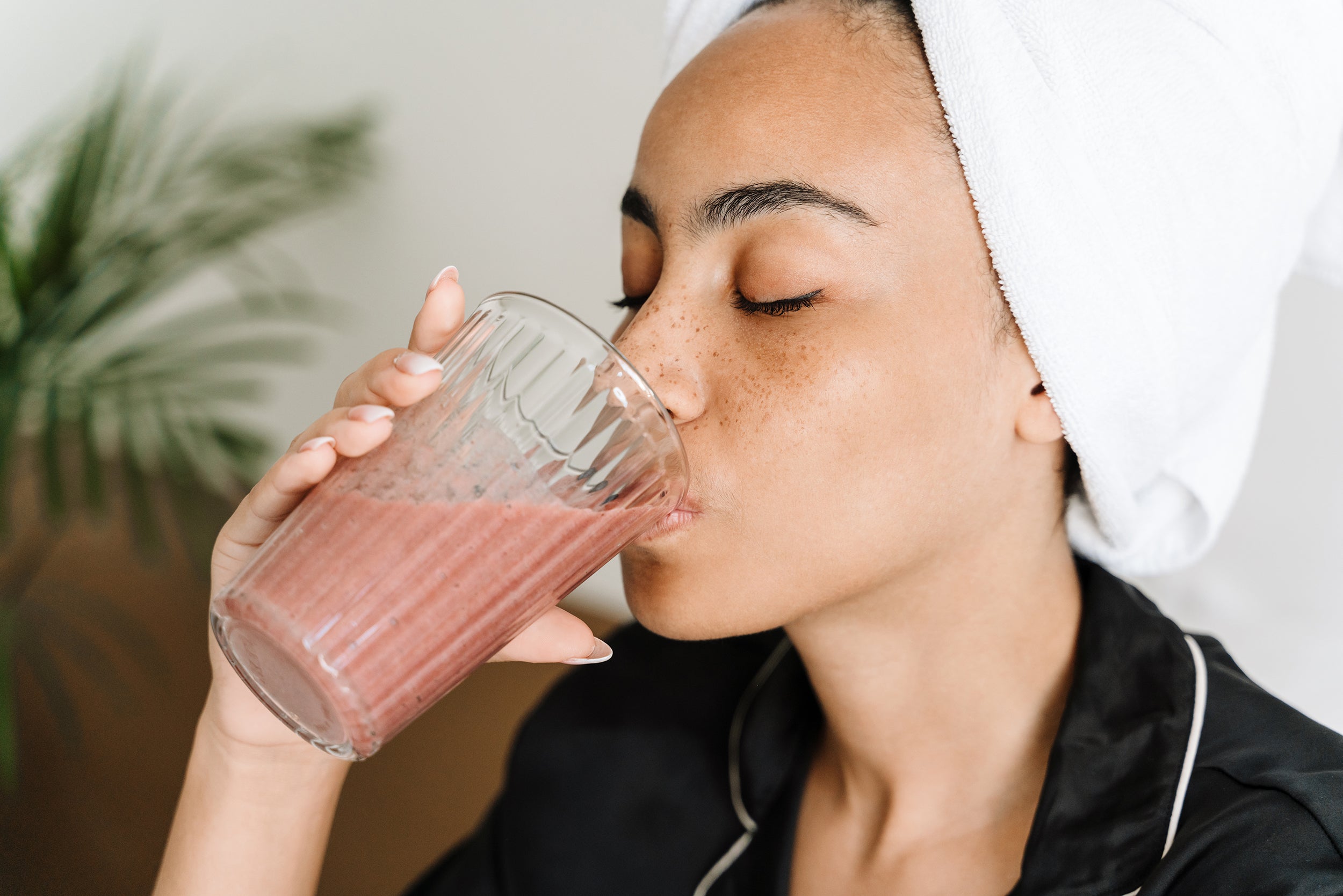 A woman drinks a smoothie. Explore our guide on what to drink after surgery and understand the simple truth about what drinks heal and which slow recovery.