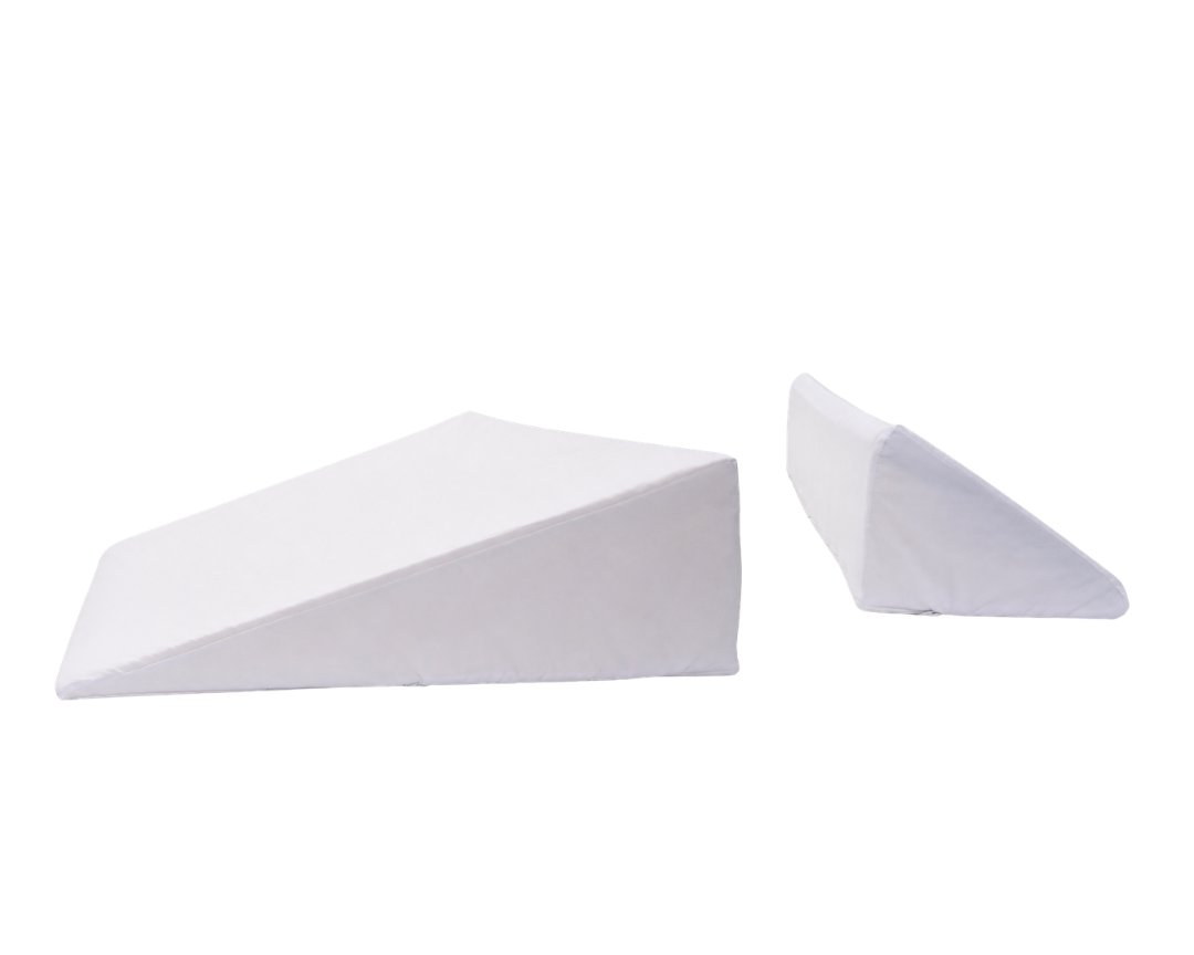 The BBL Add On Set is displayed, featuring two white foam wedge pillows of different sizes, each with a removable cover and slanted surface for support or elevation—an adaptable pillow system perfect for BBL recovery or post-surgical comfort.