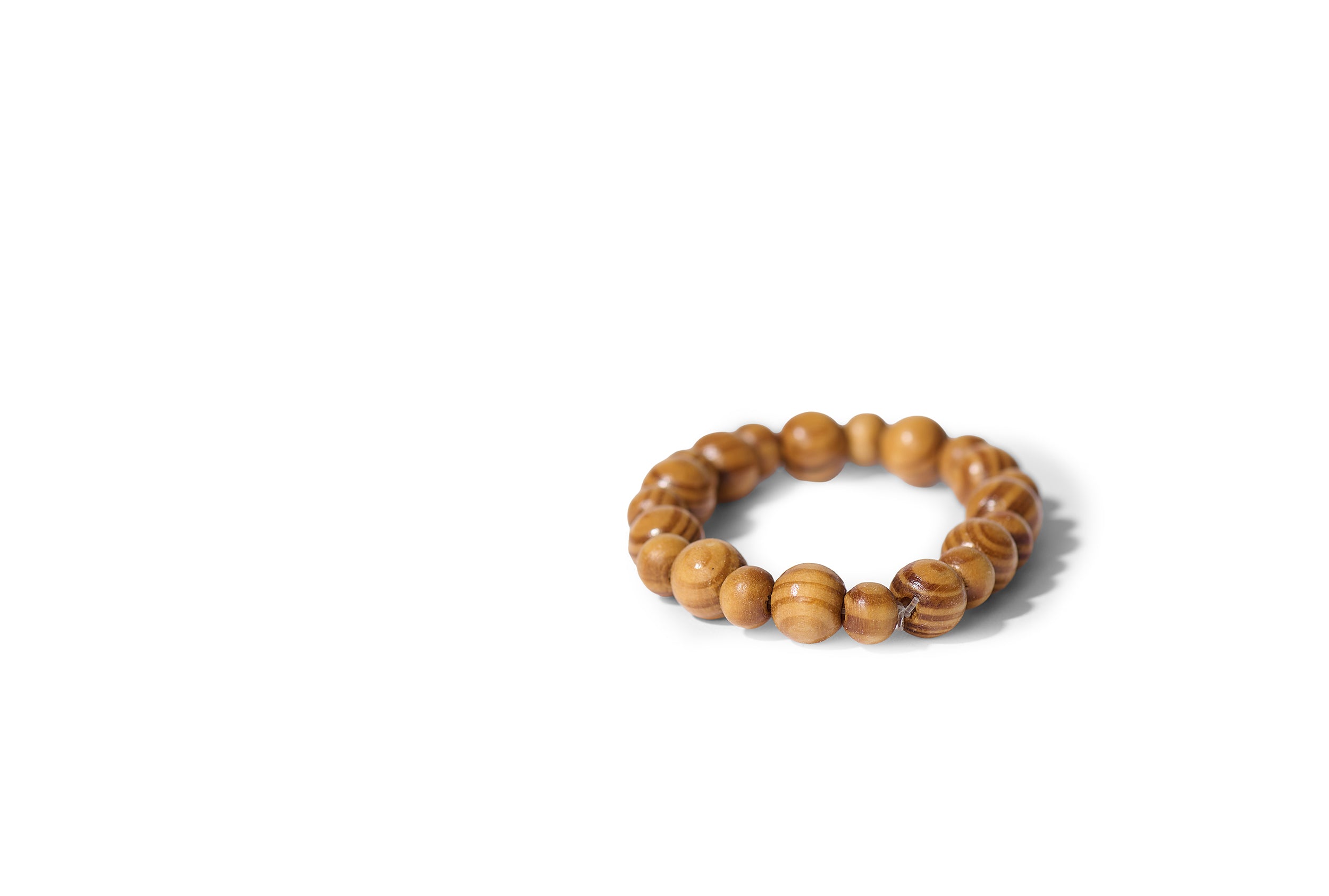 The VIP Surgical Recovery Kit includes a wooden beaded bracelet, elegantly arranged in a circle on white—an ideal gift for cosmetic surgery patients or as a thoughtful addition to any recovery kit.